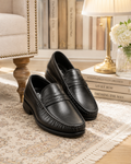 Black penny loafer with saddle strap and moccasin stitching: